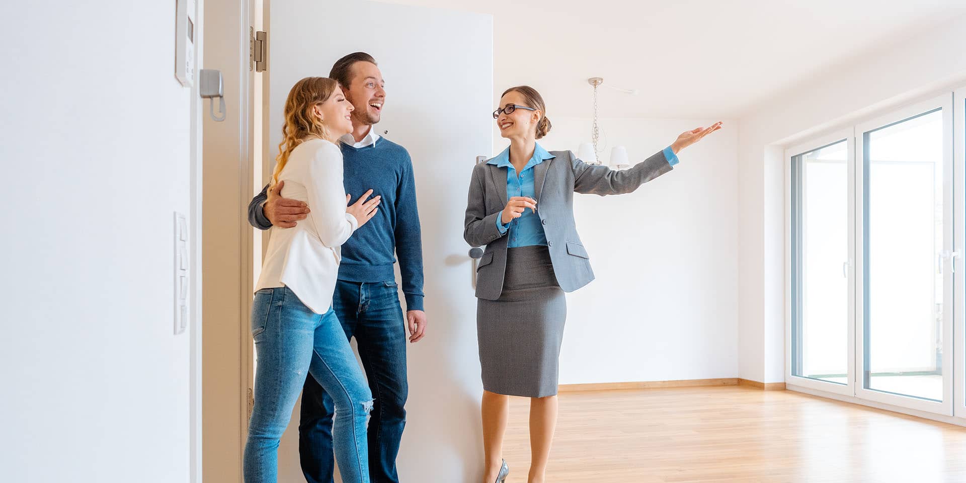 Realtor showing house to a young couple Symbolbild
